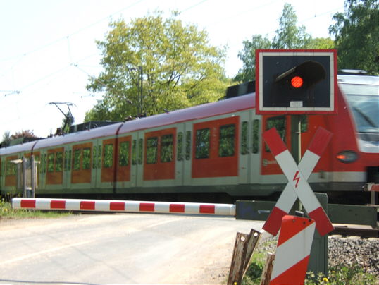 Bild: Geschlossener Bahnübergang mit S-Bahn. Sehr fein.