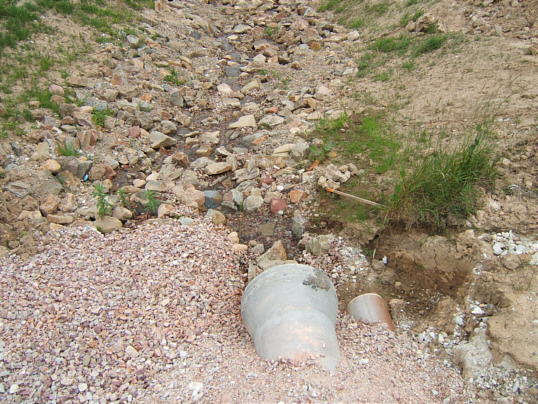 Bild: Hier fließt das Wasser aus dem Eisweiher nördlich der Straße weiter.